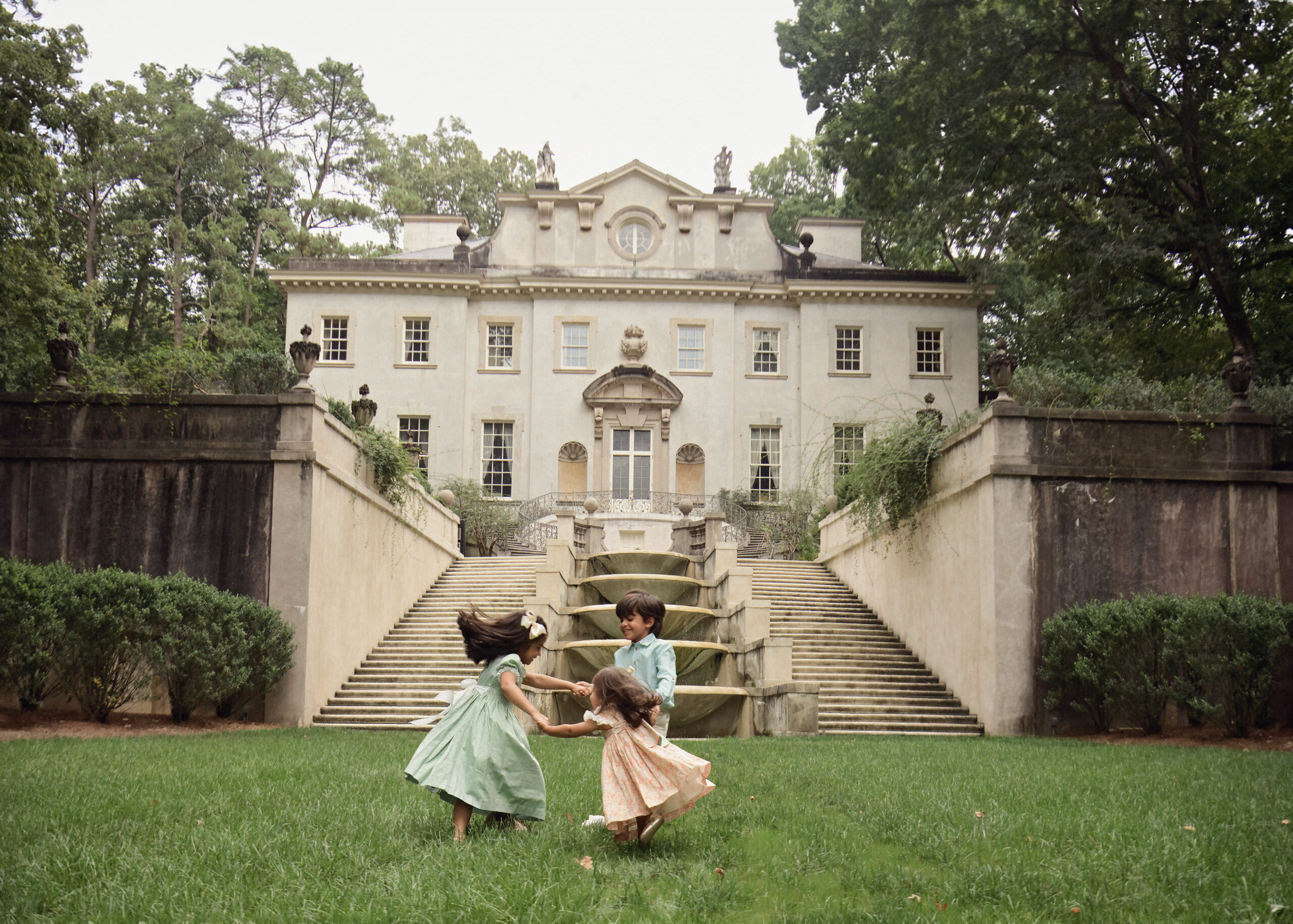 Three siblings standing in front of the Swan House in Atlanta during an editorial portrait session.